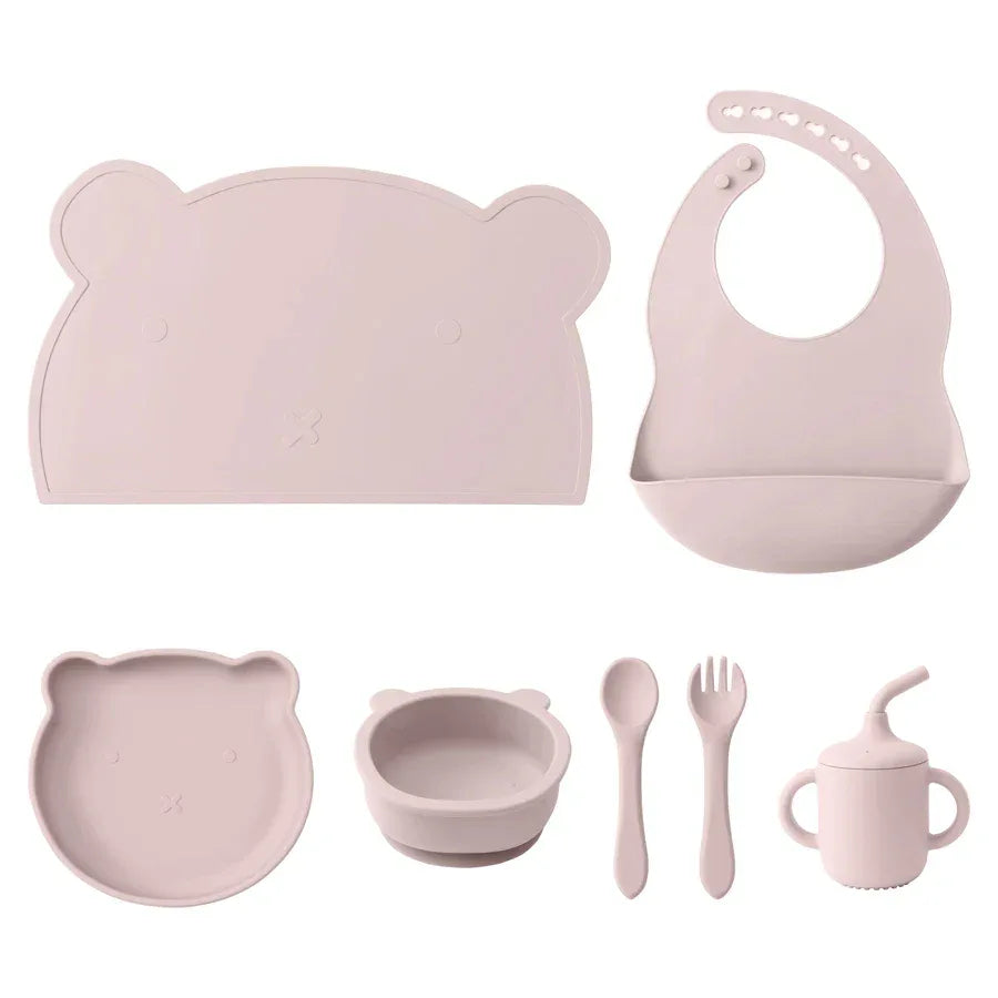 set pappa silicone neonati 7 pezzi rosa chiaro bavaglino piatto ciotola tazza posate sfondo bianco
