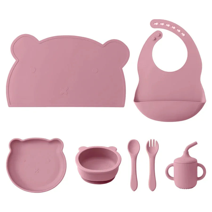 set pappa silicone neonati 7 pezzi rosa bavaglino piatto ciotola tazza posate sfondo bianco
