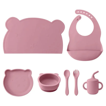 set pappa silicone neonati 7 pezzi rosa bavaglino piatto ciotola tazza posate sfondo bianco
