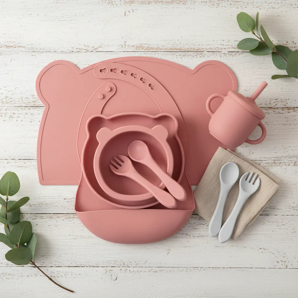 Flat lay set pappa completo 7 pezzi in silicone per neonati bavaglino piatto ventosa tazza e posate
