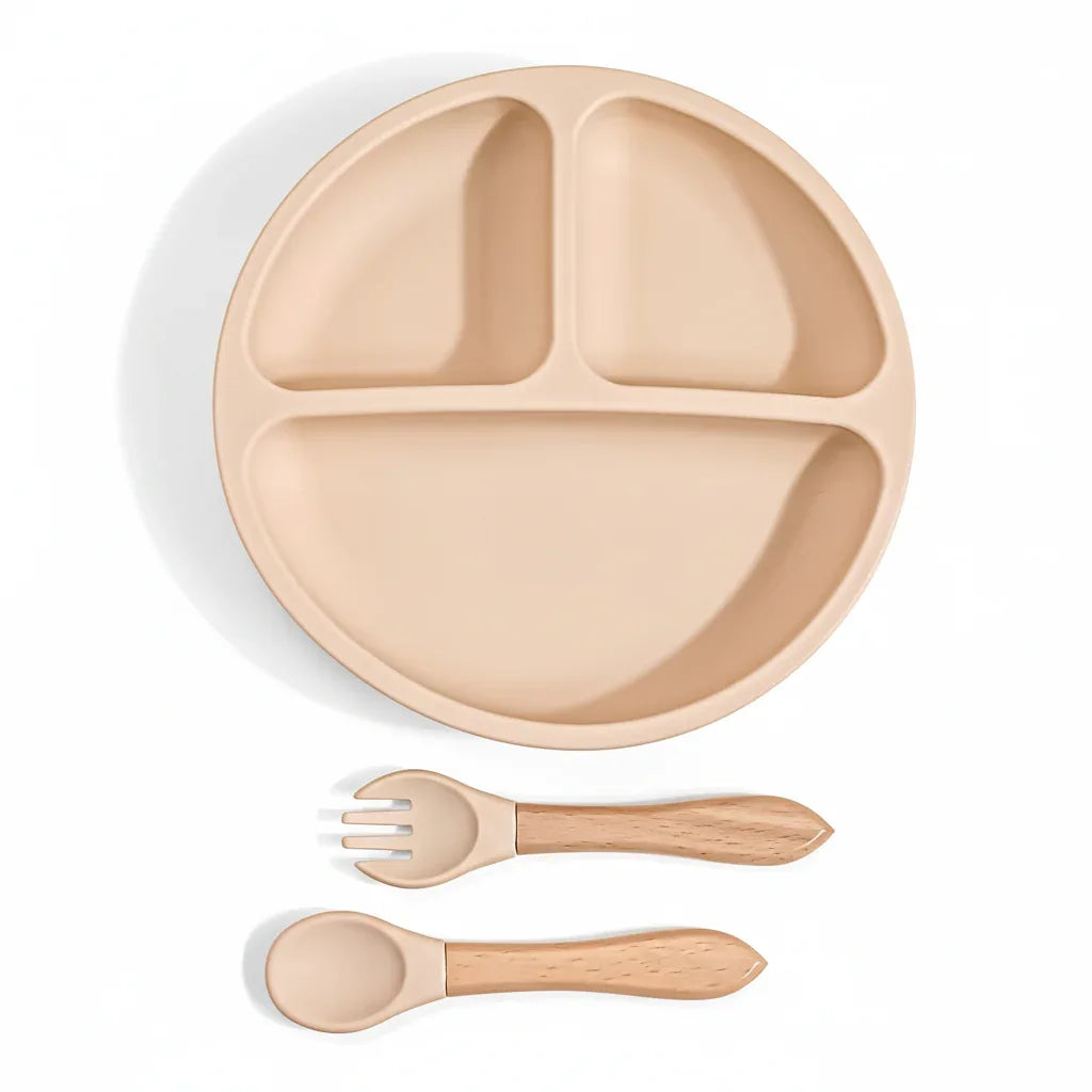 Piattino diviso in silicone beige con cucchiaio e forchetta manico legno sfondo bianco