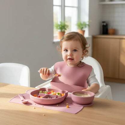 Bambino sul seggiolone che usa set pappa in silicone 7 pezzi bavaglino piatto e tazza
